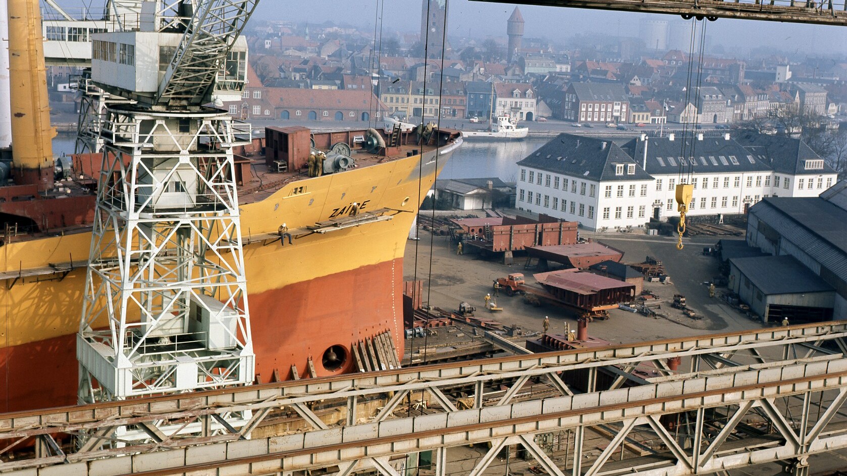 Historisk foto af Nakskov Skibsværft med værftsområde, bygninger og skibe ved havnen.