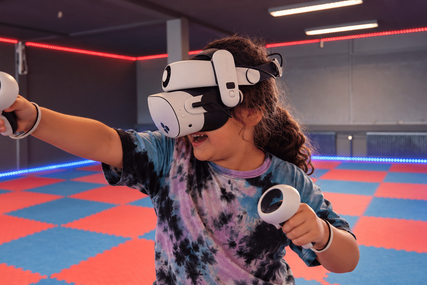 En ung gæst spiller virtual reality med headset og controllere i Nakskov VR Arena.