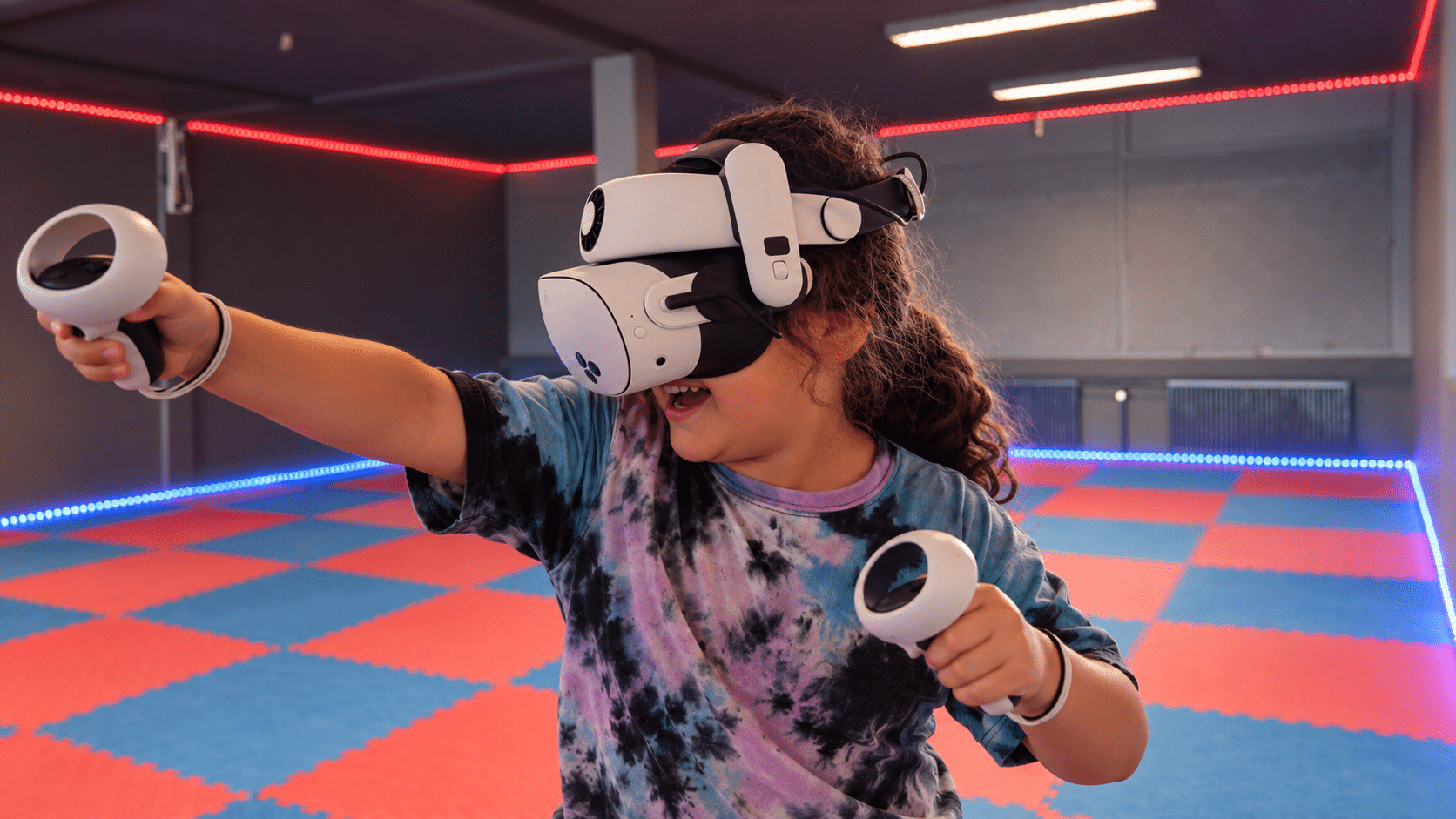 En ung gæst spiller virtual reality med headset og controllere i Nakskov VR Arena.